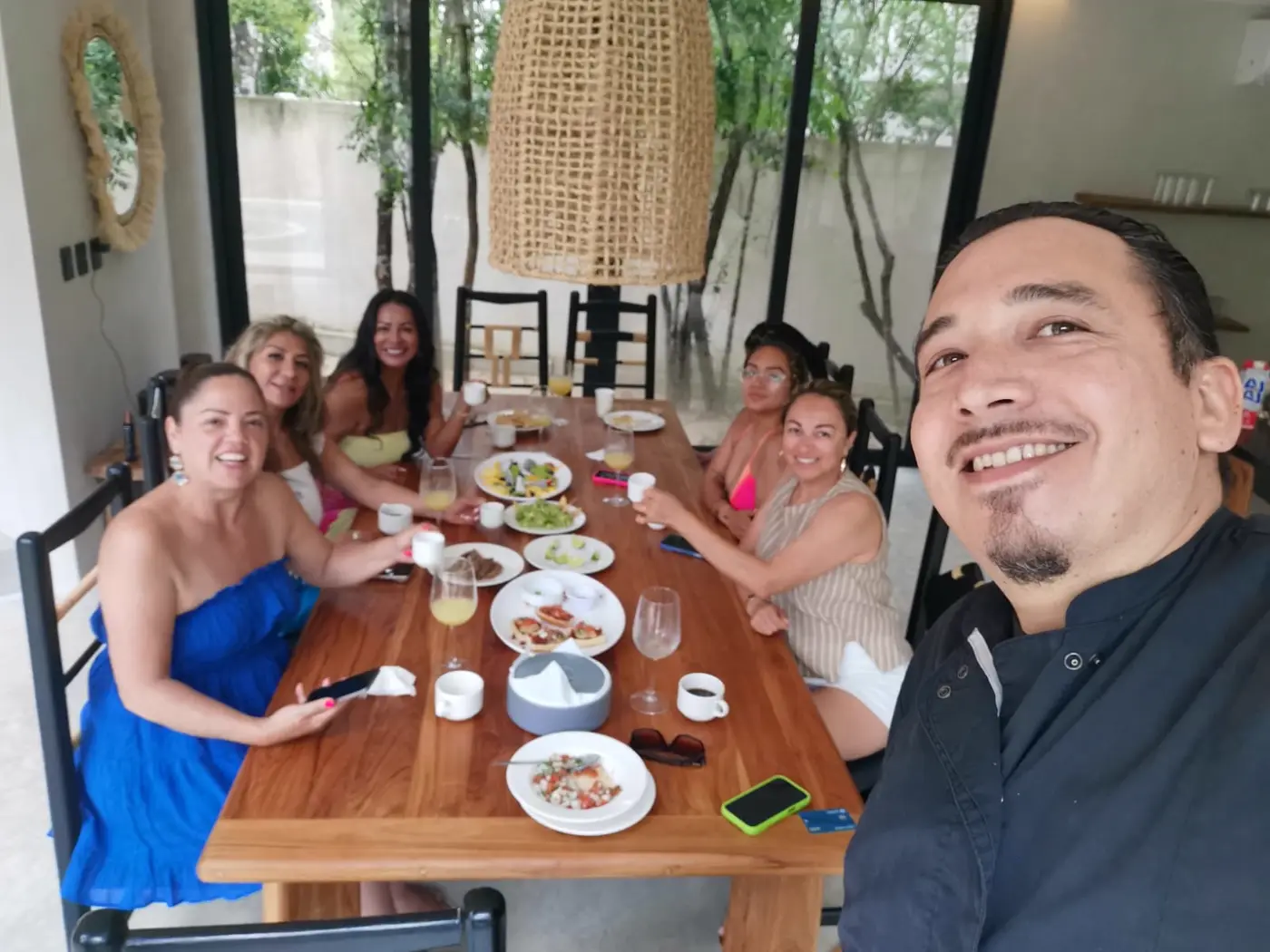 Chef and guests at a villa dining table opening onto tropical garden
